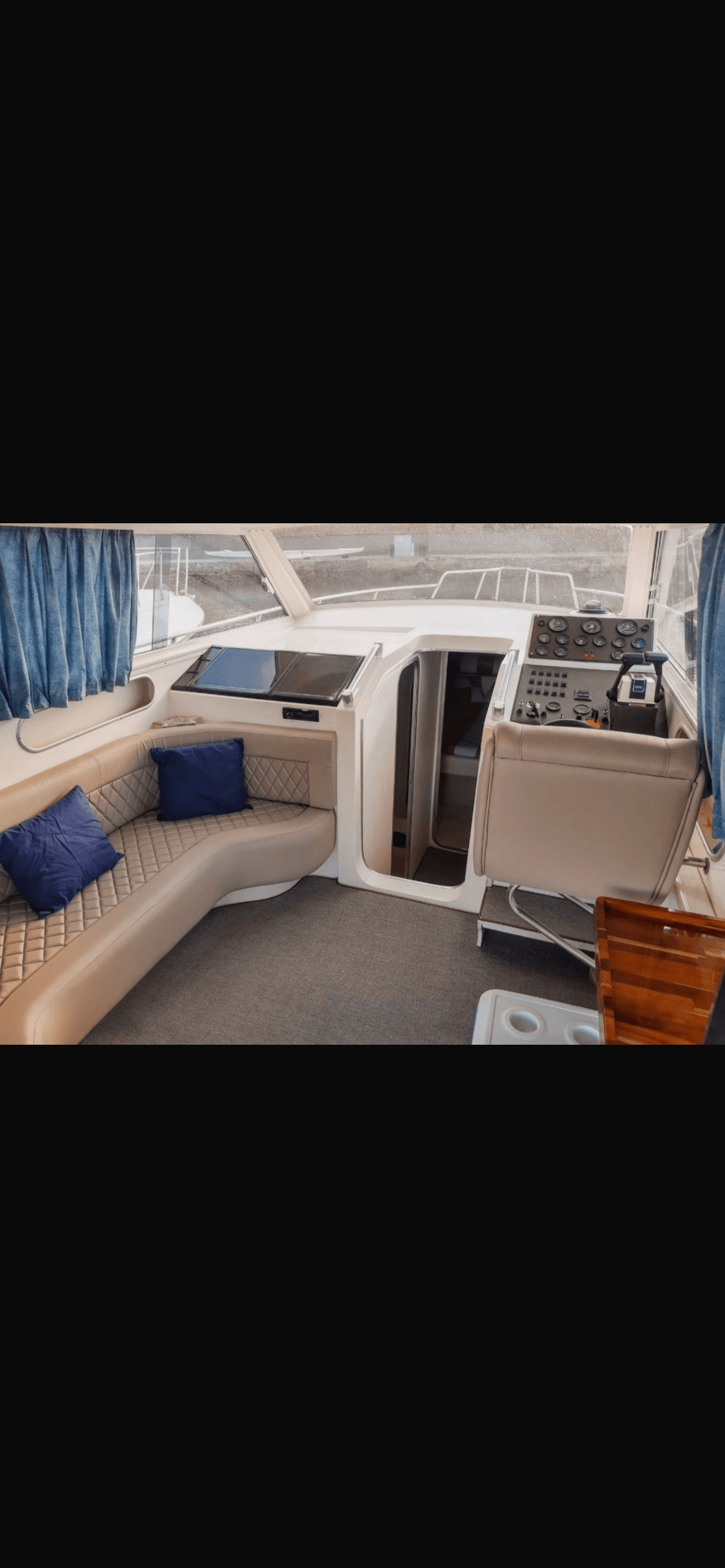 Oceanic 36 interior cabin with beige leather seating and blue pillows