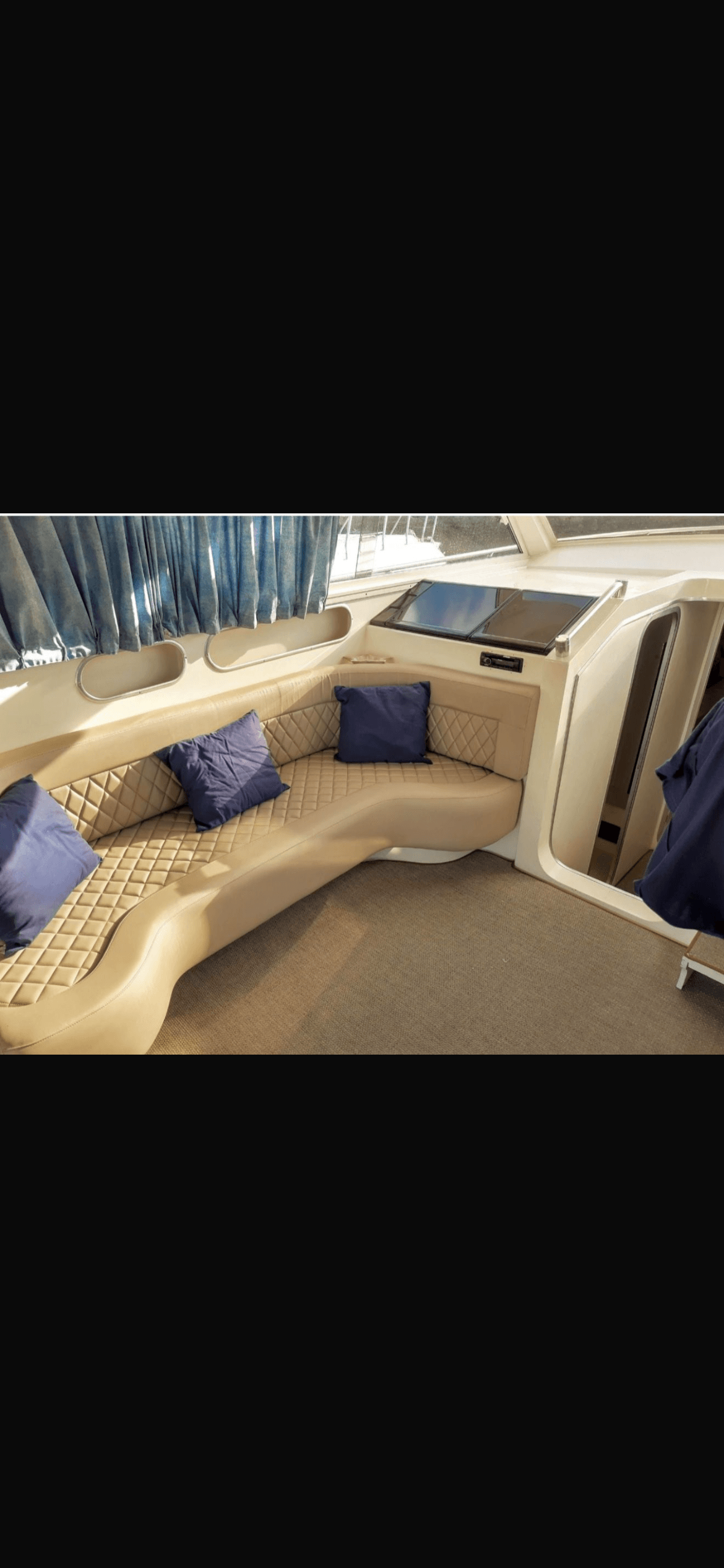 Oceanic 36 interior seating area with quilted leather and blue pillows