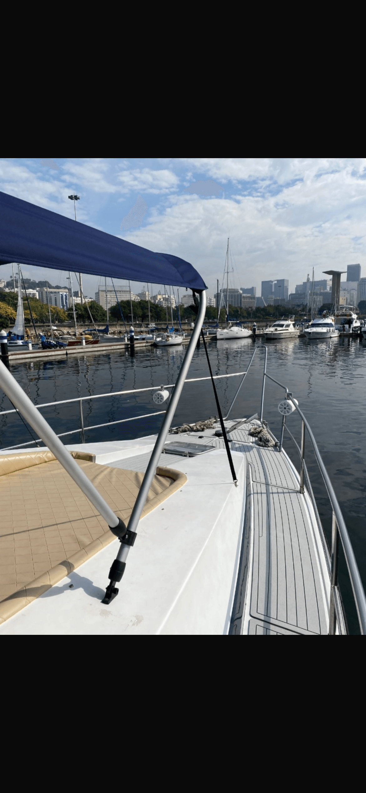 Aquarius 60 bow with blue canopy and view of the marina