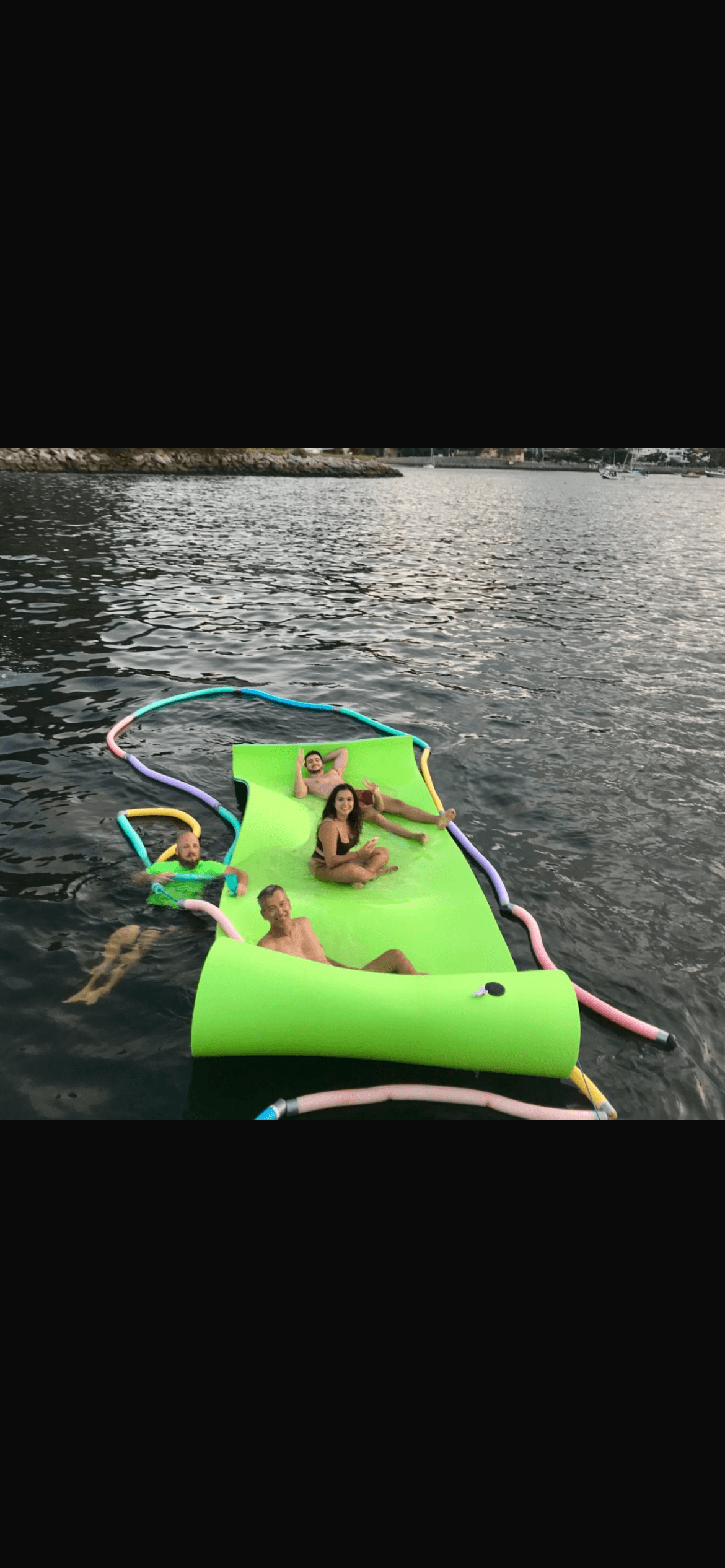 Guests enjoying a floating mat accessory from the Aquarius 60