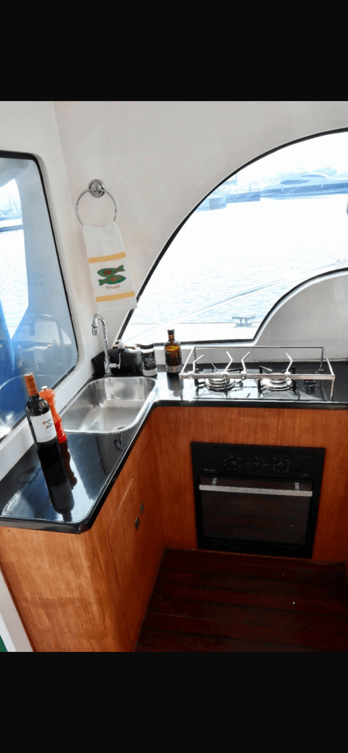 Lobster 400 interior galley with sink, stovetop and wooden cabinetry