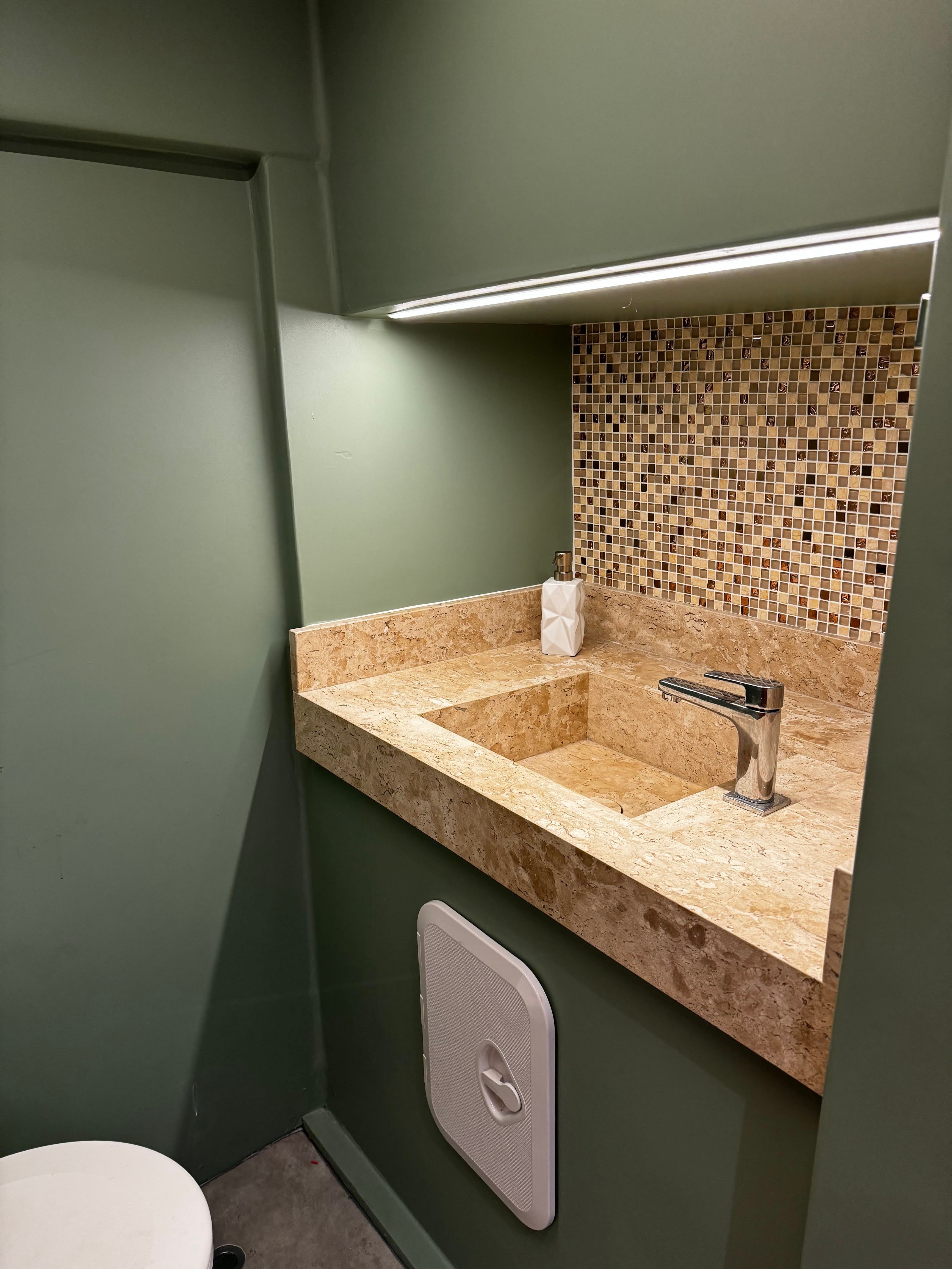 Modern bathroom with stone sink and mosaic tile backsplash