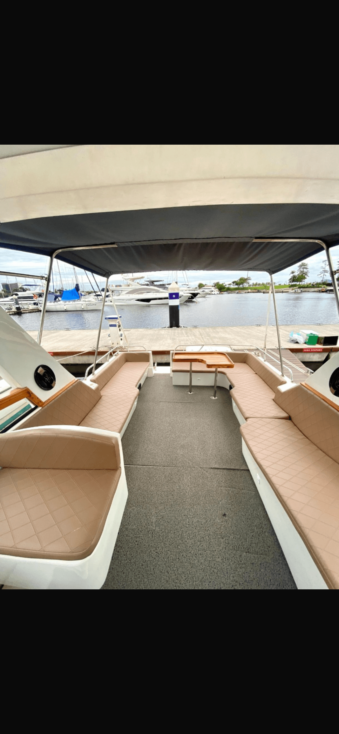 Rival 36 deck area with beige upholstered seating and wooden table