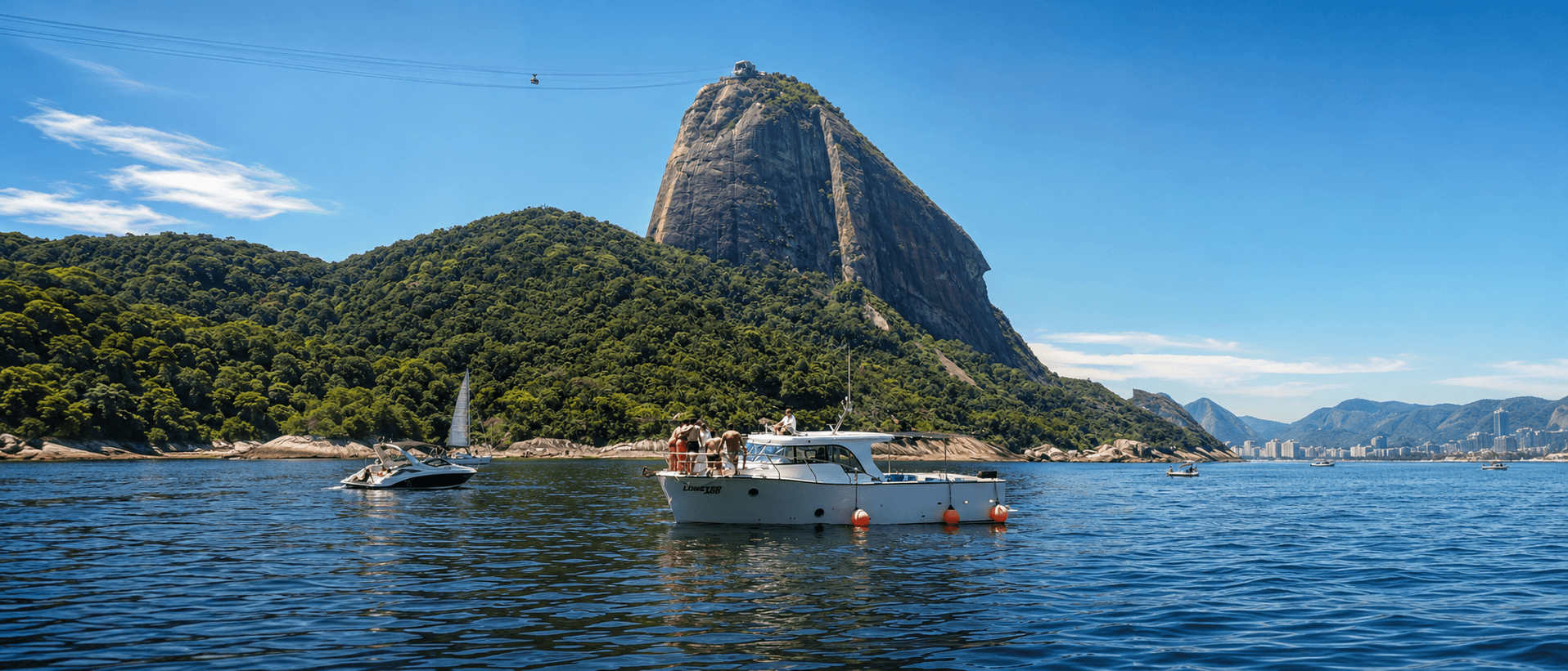 Barco com passageiros navegando na Baía de Guanabara com o Pão de Açúcar ao fundo