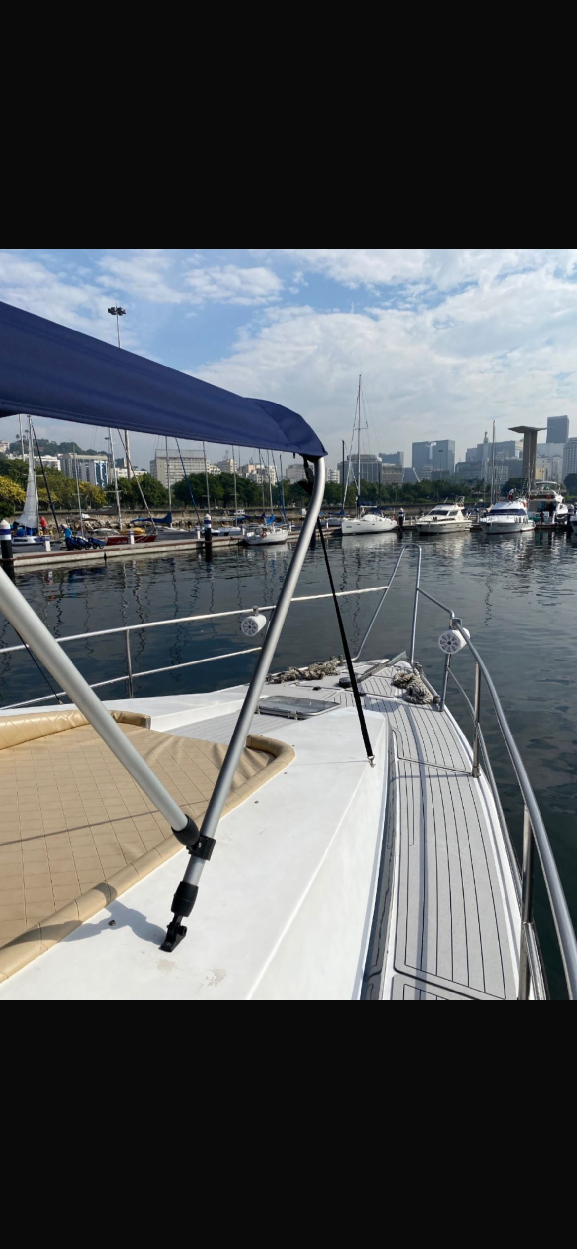 Aquarius 60 bow with blue canopy and view of the marina